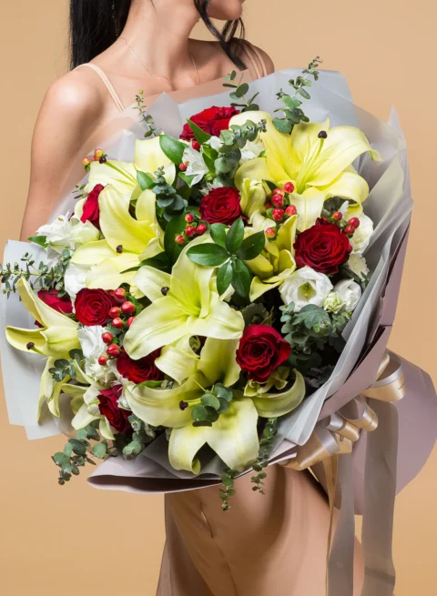 A bouquet of yellow lilies and red roses