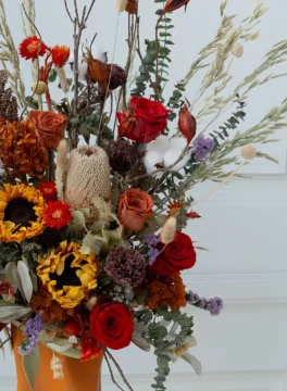 Queen Bee dried flower in vase with bright yellow, red, and white preserved blooms