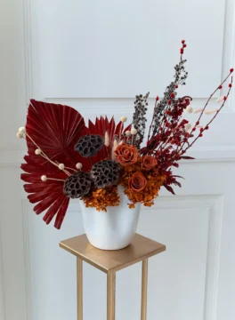 Oriental Sails dried flower in vase with dark red palm leaves and brown roses