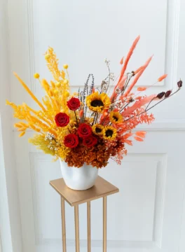 Funfetti dried flower in vase with sunflowers, red roses, and brown hydrangea