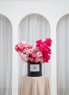 Elegant Capella Classic black round box with roses, pearl flowers, and sweet william