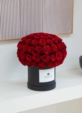 A red round flower box made entirely from roses on the side.