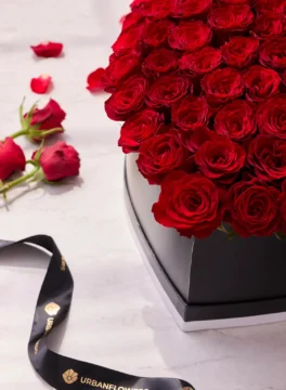 Premium red roses with a black heart-shaped flower box