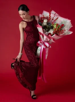 Red and green Christmas fresh flower bouquet with model
