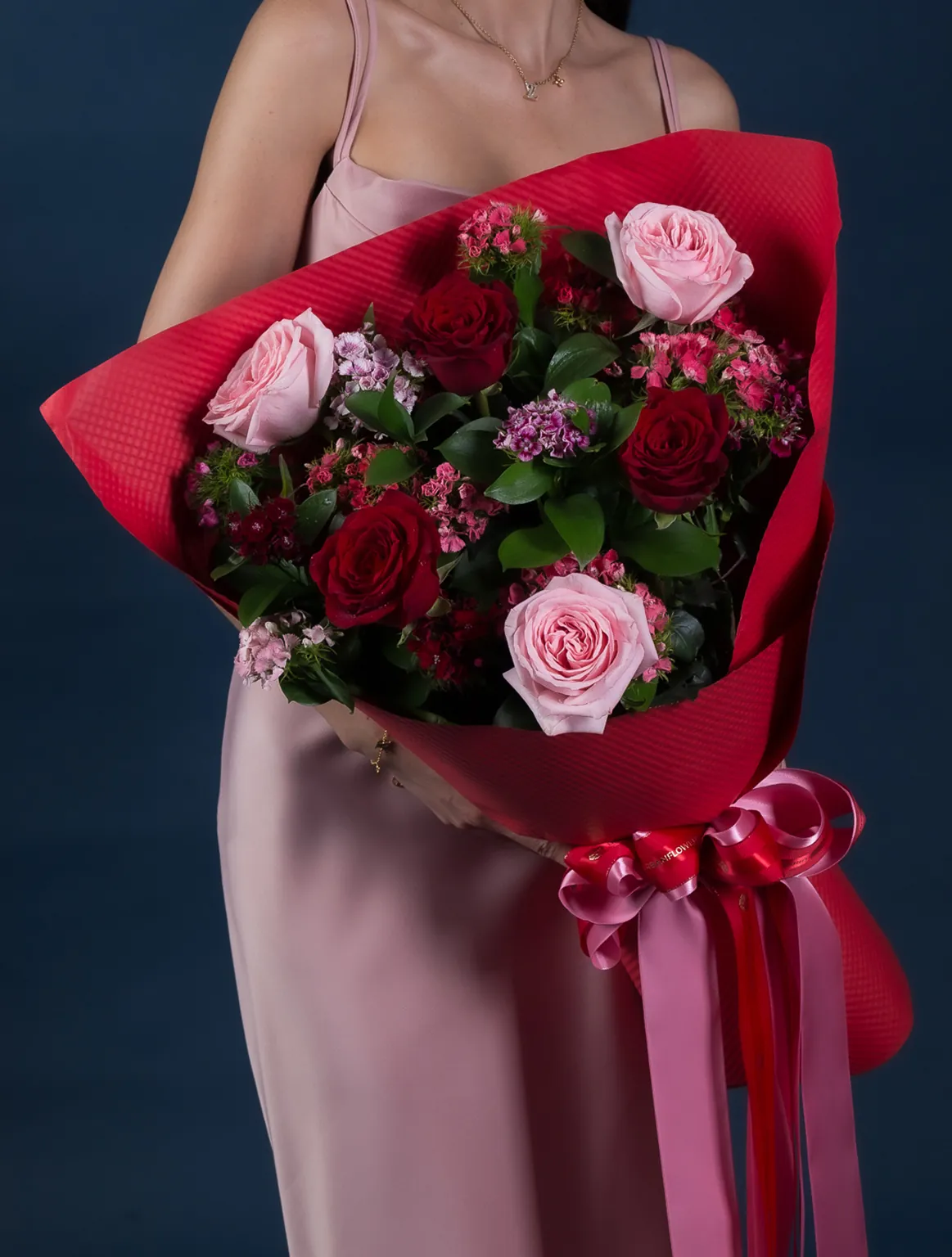 Bouquet of red and pink roses, red paper