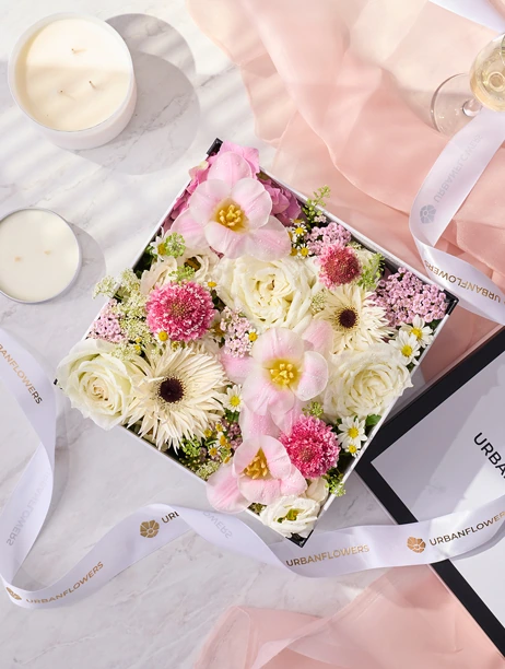 Pink and cream flower box featuring roses and daisies in a cute design