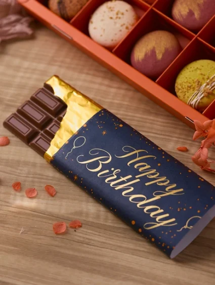 ช็อกโกแลตแท่งแฮปปี้เบิร์ธเดย์ ช็อกโกแลตนมพรีเมียมห่อด้วยแพ็กเกจสีน้ำเงินทองสุดหรู พร้อมมาการองหลากสี