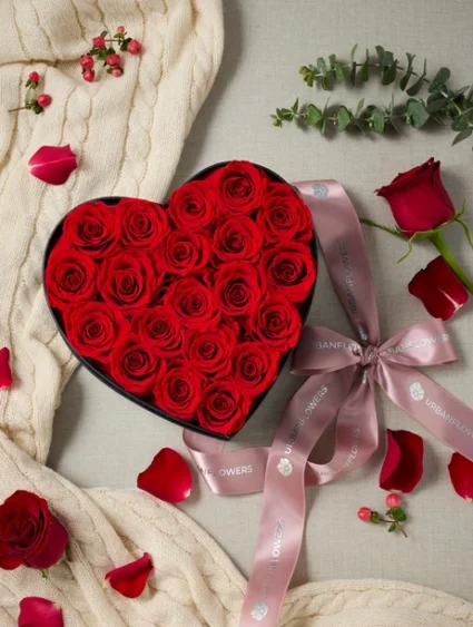 กุหลาบอมตะในกล่องรูปหัวใจ ดอกกุหลาบแดงจัดเรียงอย่างหรูหรา ผูกริบบิ้นซาติน เหมาะเป็นของขวัญรักสุดโรแมนติกที่คงความงามยาวนาน