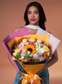 Bouquet of sunflowers and white roses wrapped in colorful paper