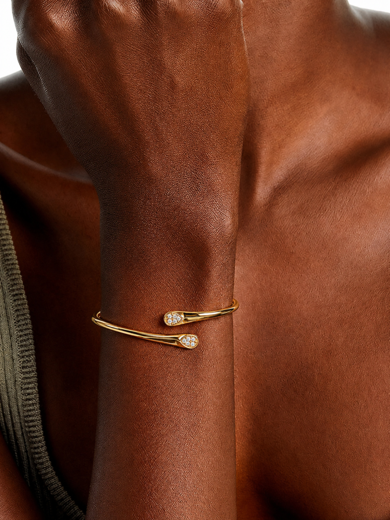 Gold vermeil open bypass cuff bracelet with pavé crystal teardrop tips, worn on wrist.