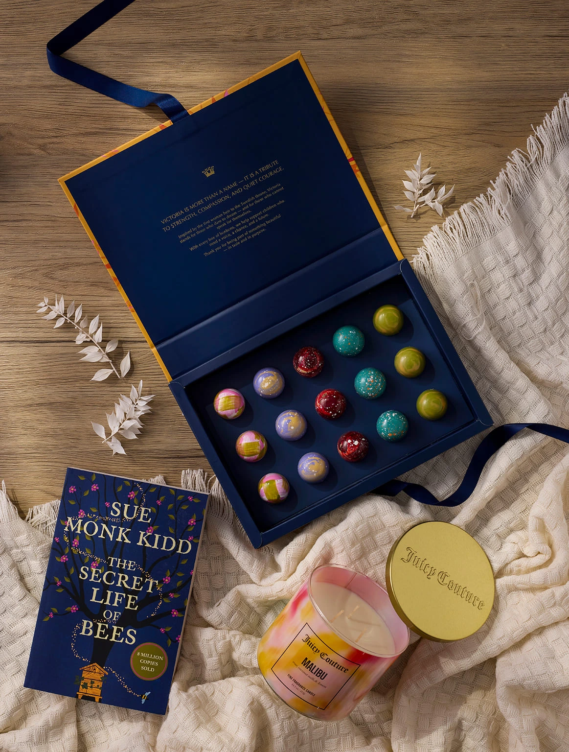 luxury-gift-set-chocolate-bonbon-box-scented-candle-book-wooden-table-flat-lay