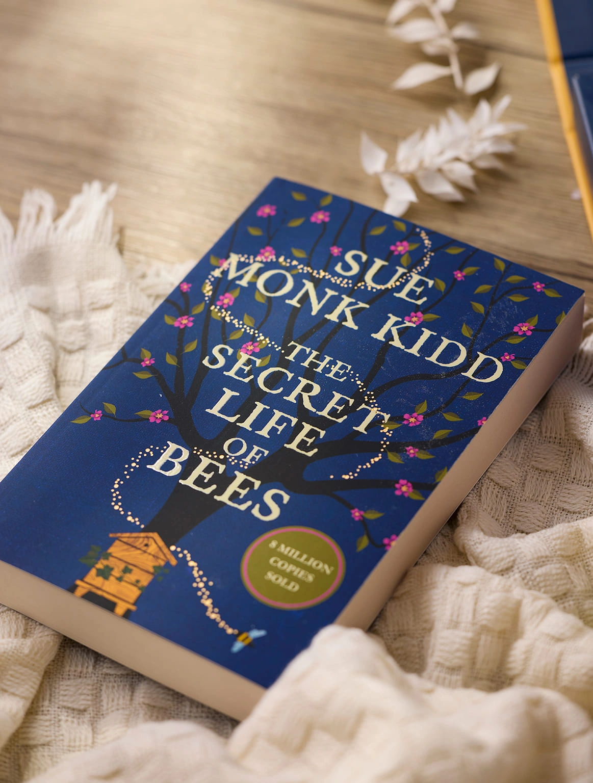 the-secret-life-of-bees-book-cream-blanket-wooden-table-close-up